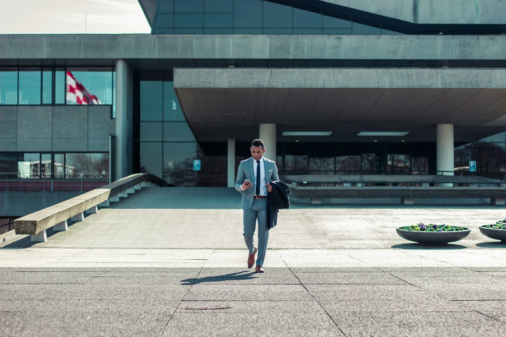 man walking while holding black coat